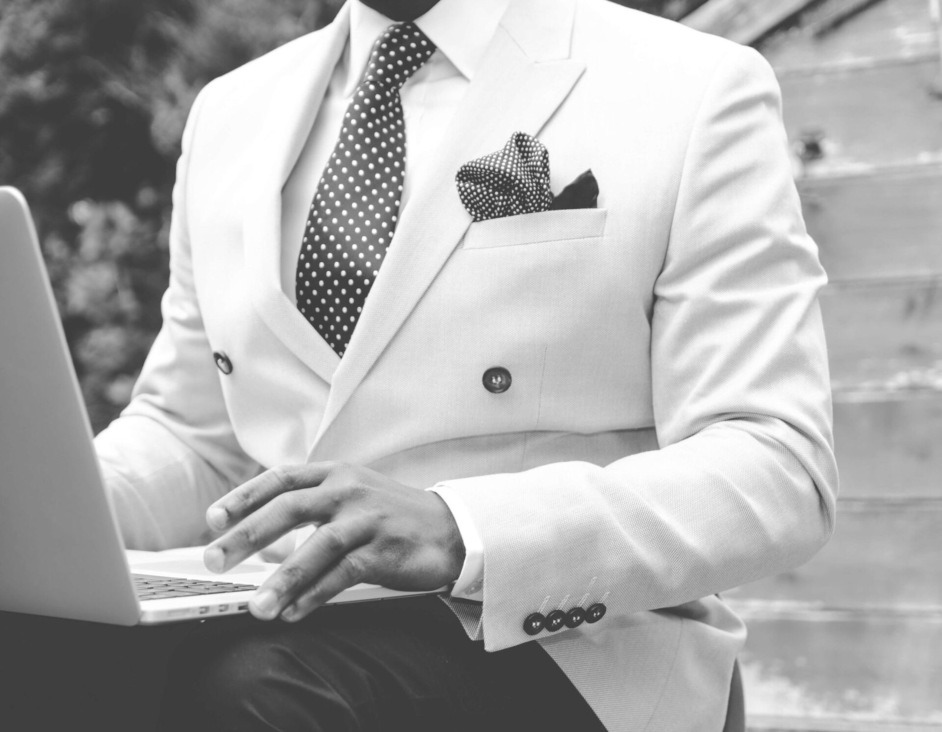 A spotted tie and spotted pocket square worn with a cream double-breasted jacket
