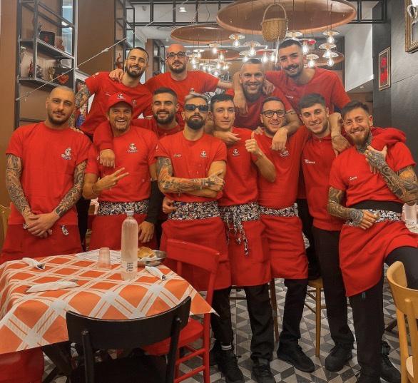 The dining room staff in the house red — the singing is part of the service