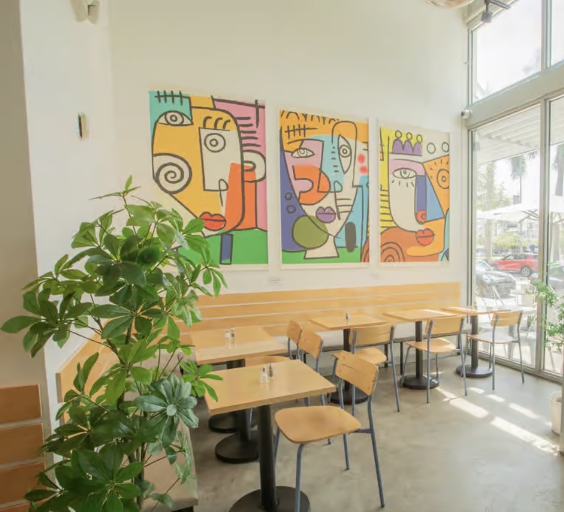 Angelina's café interior with colorful abstract mural and sunlit tables