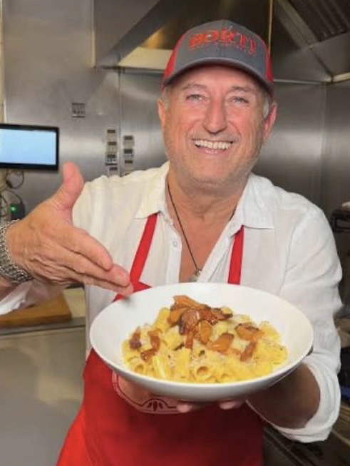 Chef at BORTI Pasta Bar presenting a bowl of rigatoni